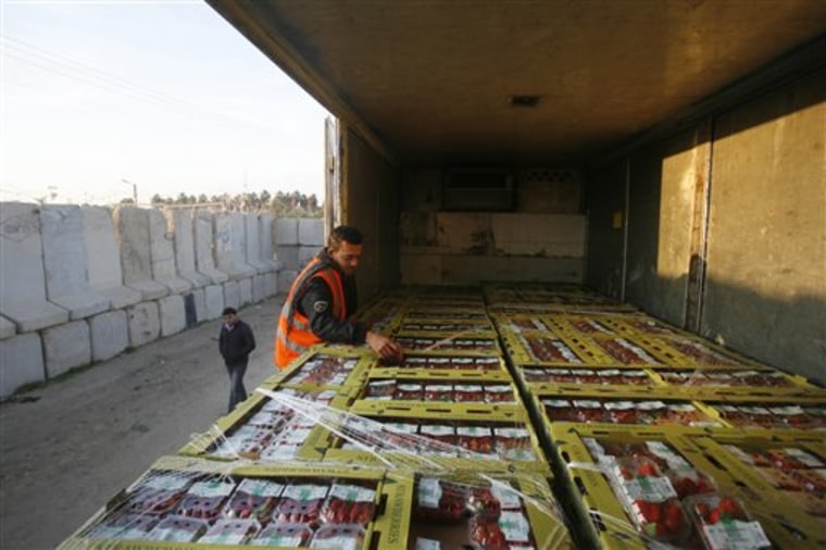 A Palestinian customs worker checks a truck loaded with boxes of strawberries waiting at Kerem Shalom crossing between the Gaza Strip and Israel, on Sunday. Farmers in the Hamas-ruled Gaza Strip began exporting tons of produce to Europe, after Israel cracked open its its volatile border with Gaza for Palestinian goods. A truckload of strawberries left Gaza to launch the season, which is to run through May. 